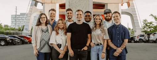 The Awaken worship band poses for a photo underneath a bridge.