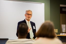 A professor lectures students in a classroom.