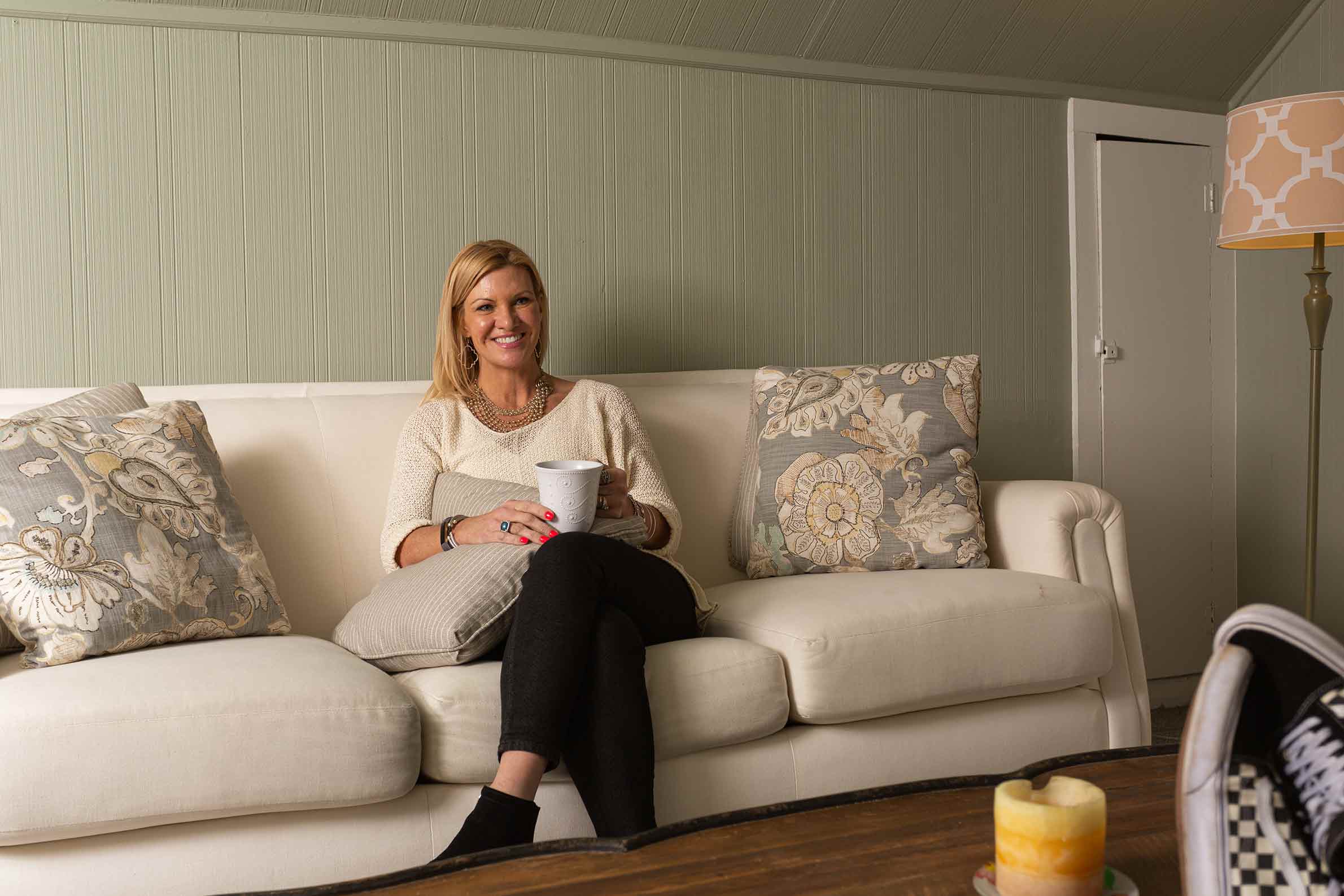 A counselor sits on a couch in their office, ready to greet students.